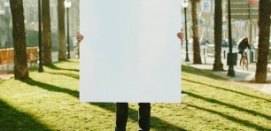 A man holding a white poster