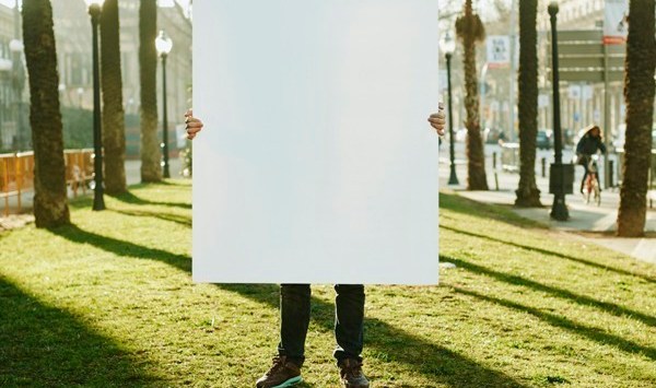 A man holding a white poster