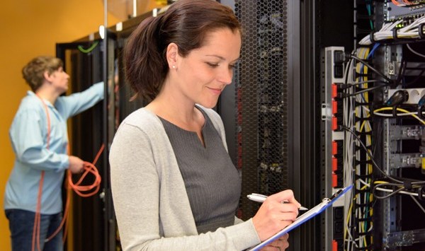 Woman IT engineer in server room checking network