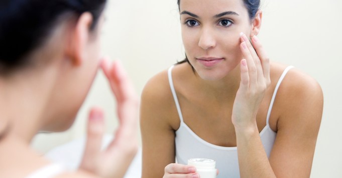 Woman applying skincare product