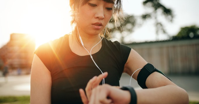 Woman using her fitness tracker while exercising; wearable technology