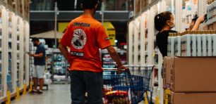 man shopping in supermarket aisle with trolley