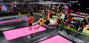 Kid bouncing in the air over a BOUNCE trampoline